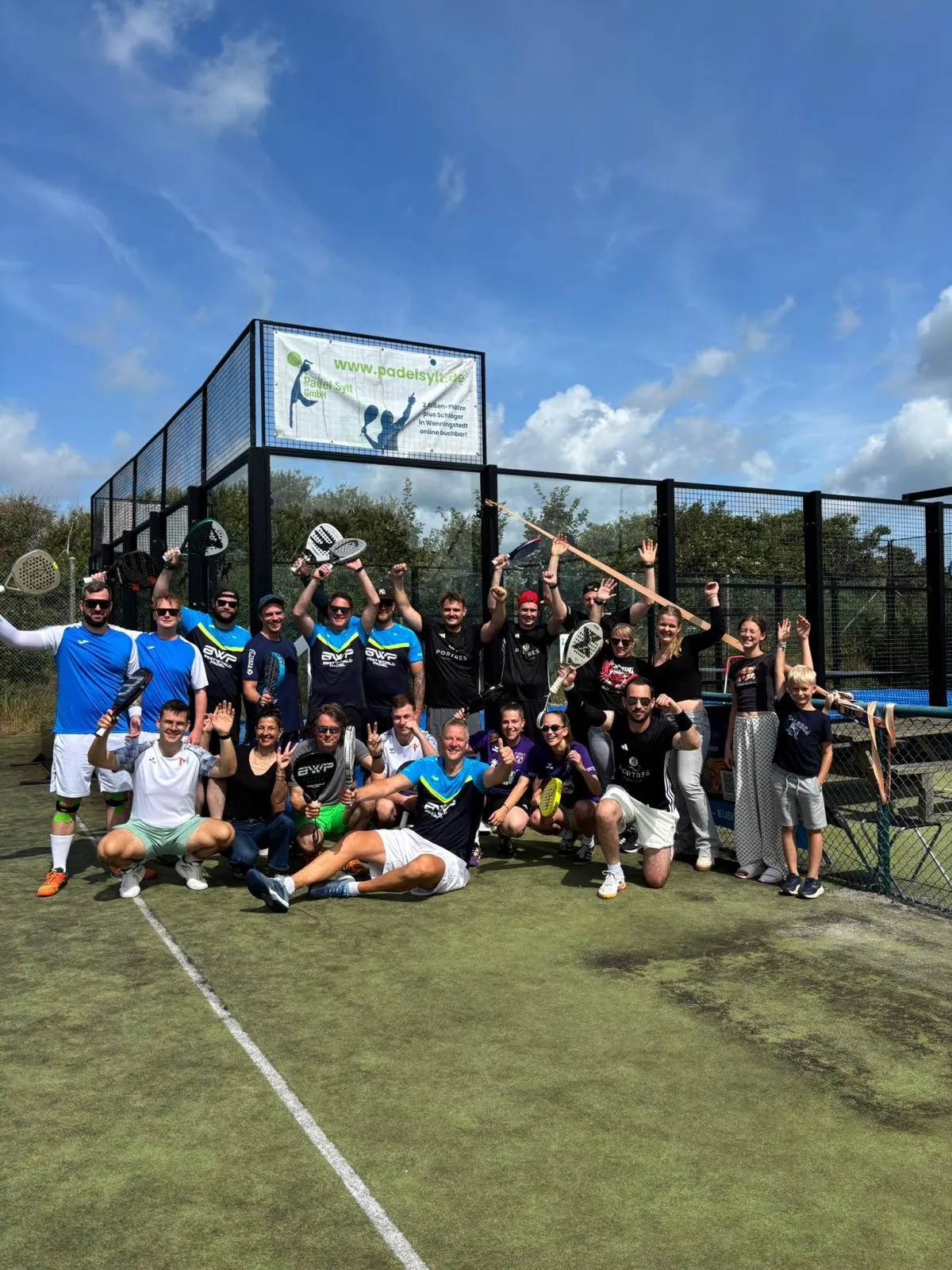 Große Gruppe von Spielerinnen und Spielern jubelt vor den Padelplätzen von Padel Sylt